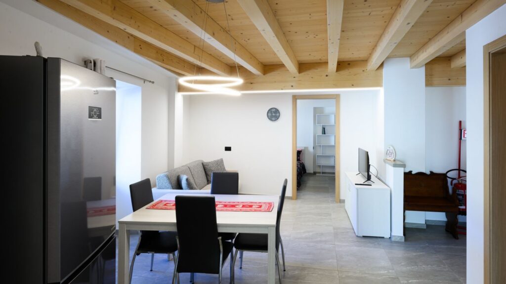 Soggiorno luminoso con travi in legno e cucina dell'Appartamento Ambro